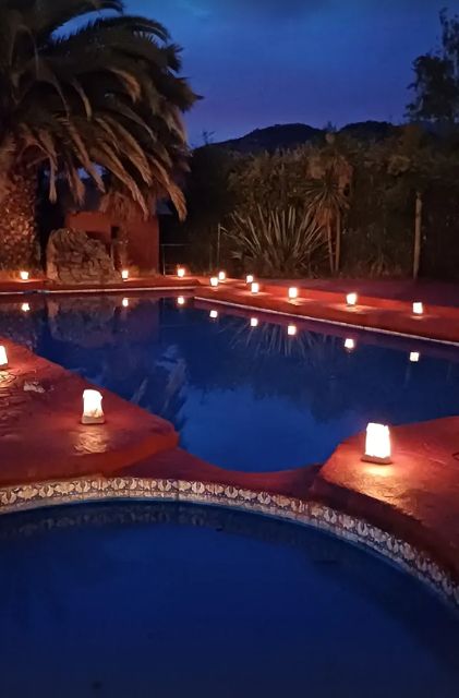 Piscina iluminada con velas al anochecer